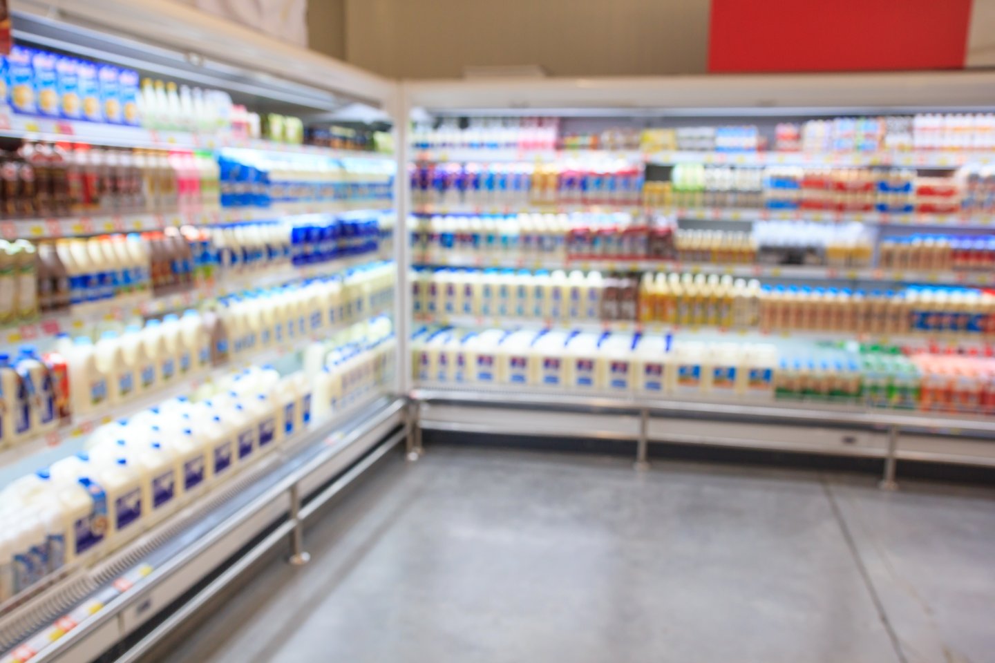 Defocused blur of supermarket shelves with dairy products. Blur background with bokeh. Defocused image