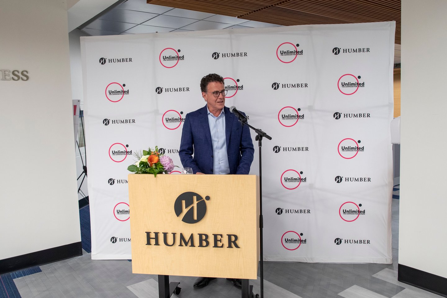 Anthony Longo standing at a podium in front of a Humber College branded step and repeat