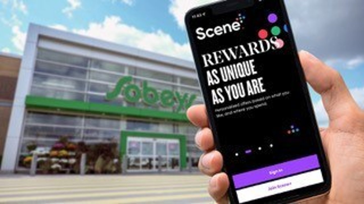Scene loyalty mobile app held in front of a Sobeys store