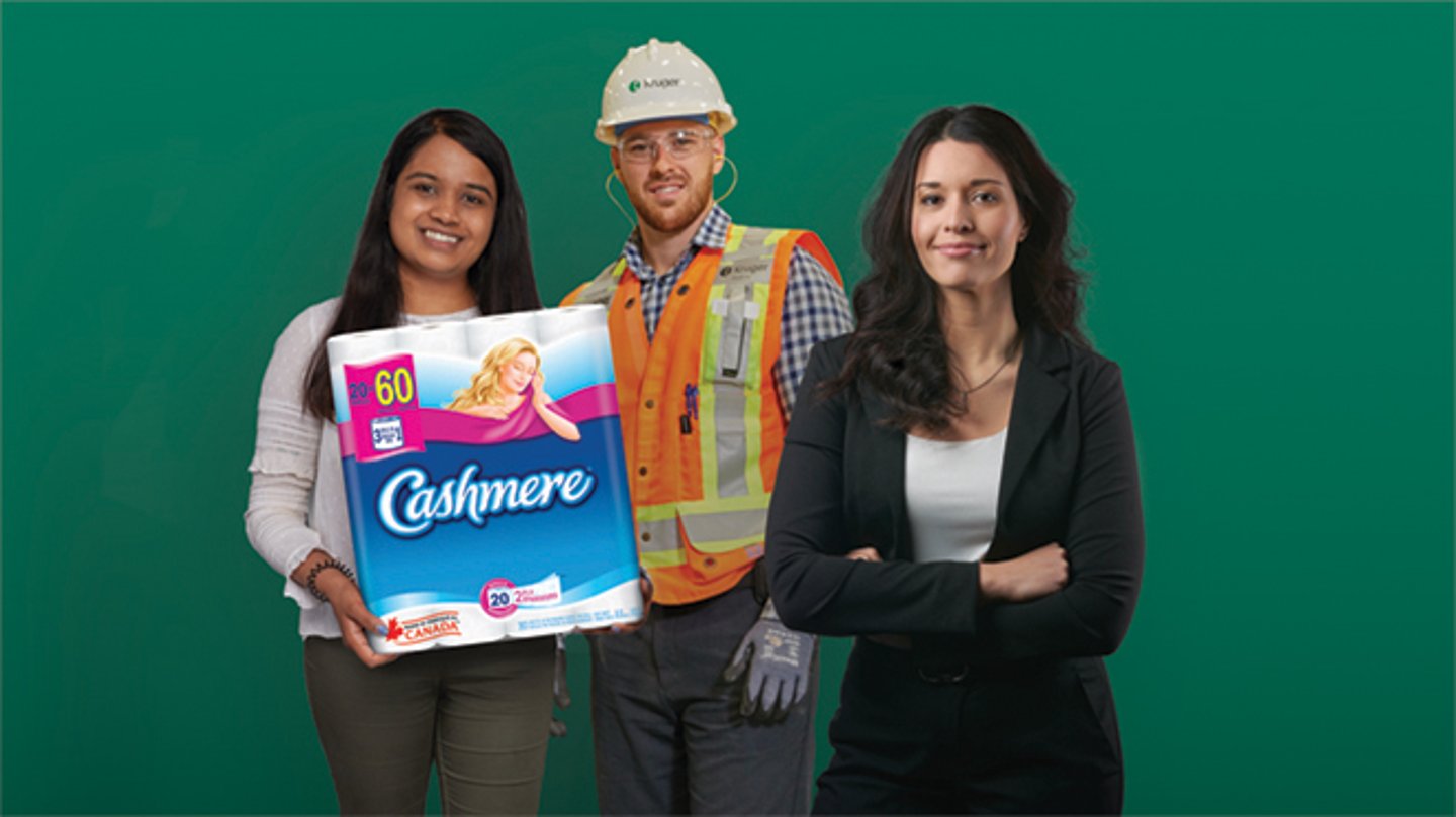 Three people standing side by side, one holding a pack of toilet paper