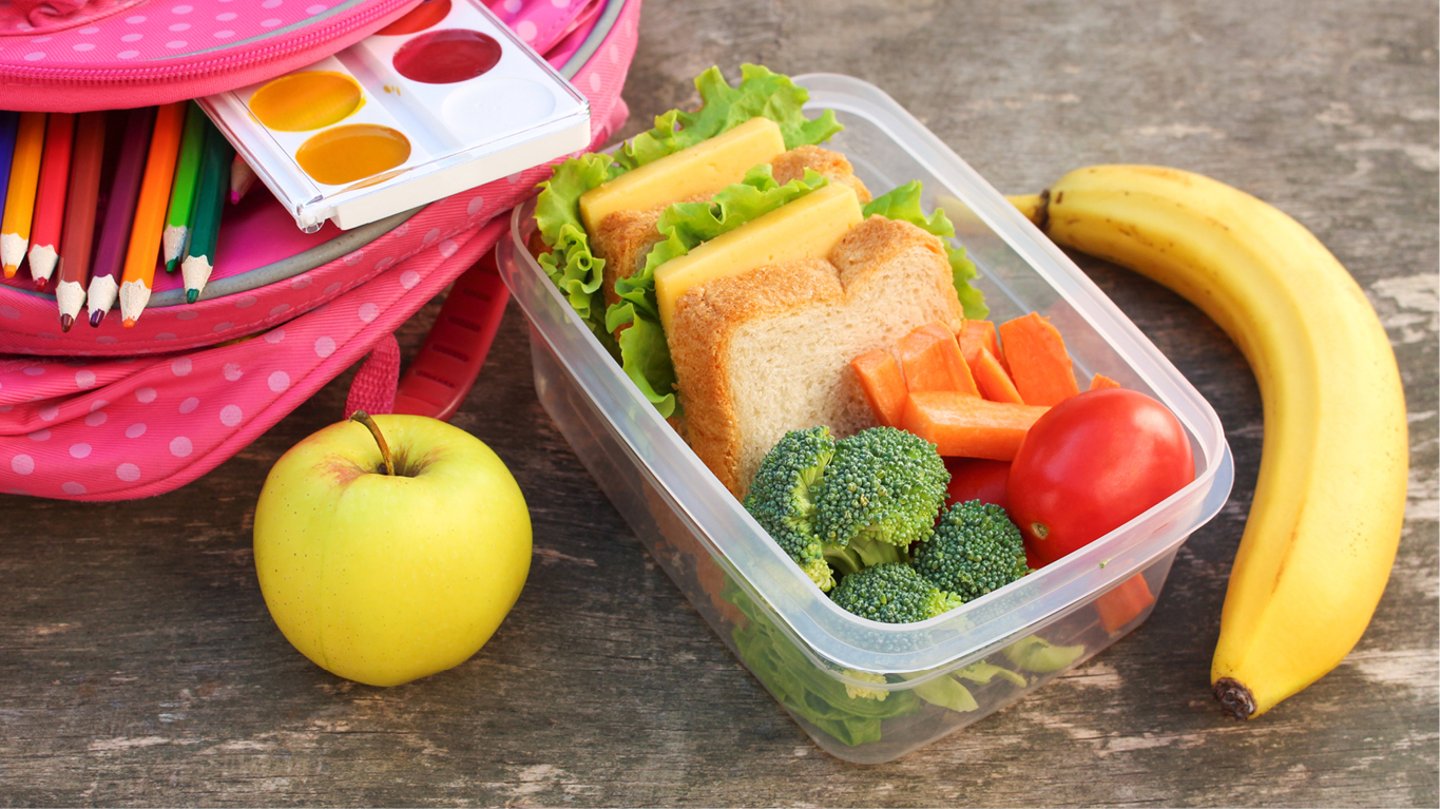 lunch bag on a table with a container and a banana