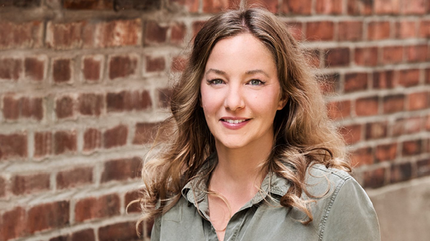 Kim Wiseman standing in front of a brick wall