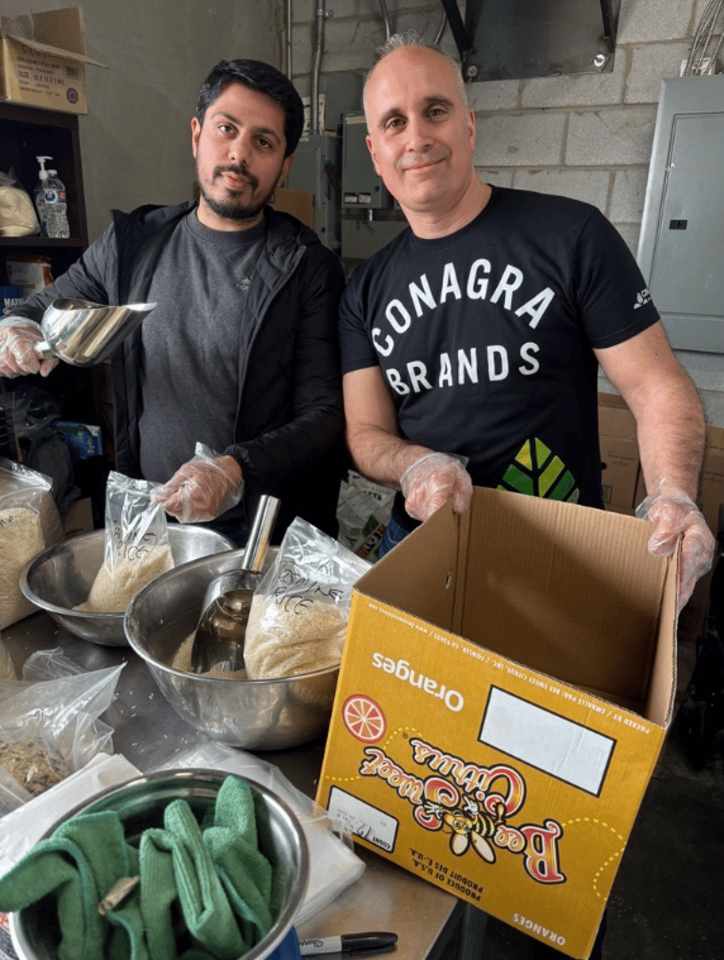 Two men packing boxes with food