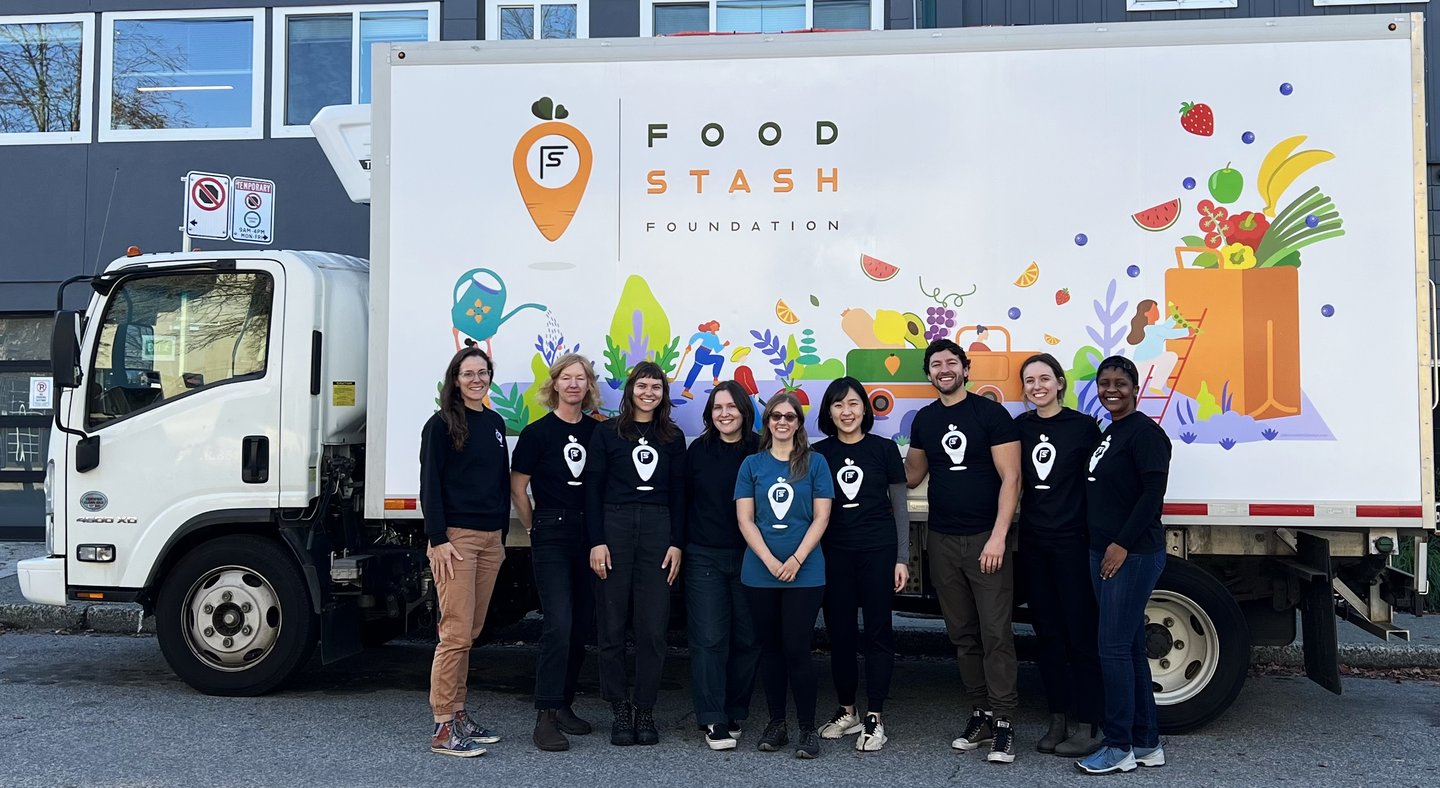 A group of people standing in front of a Food Stash van