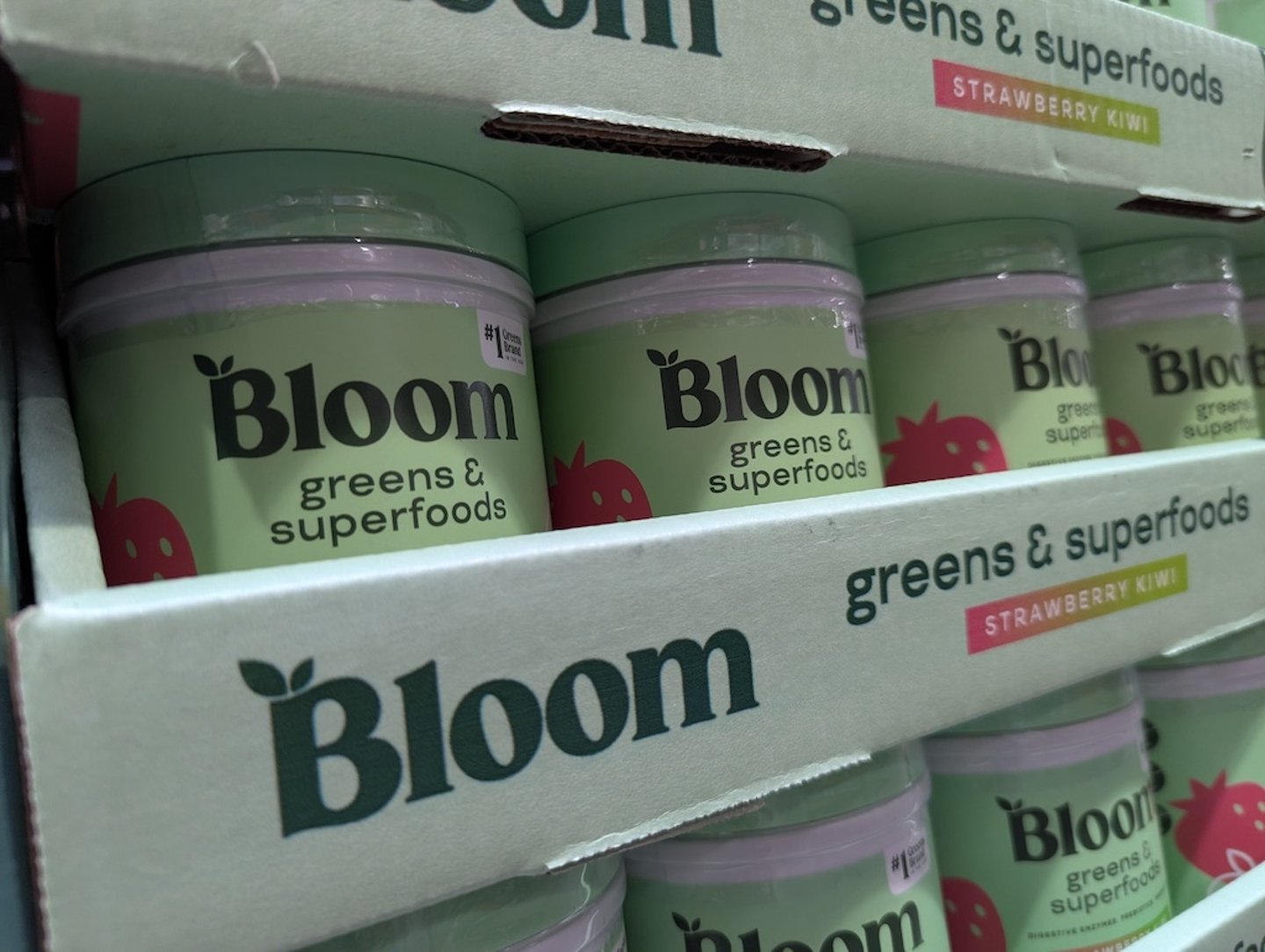 Bloom Nutrition greens and superfoods in strawberry kiwi on a shelf 