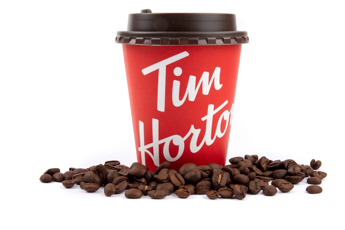 Tim Hortons coffee cup surrounded by beans