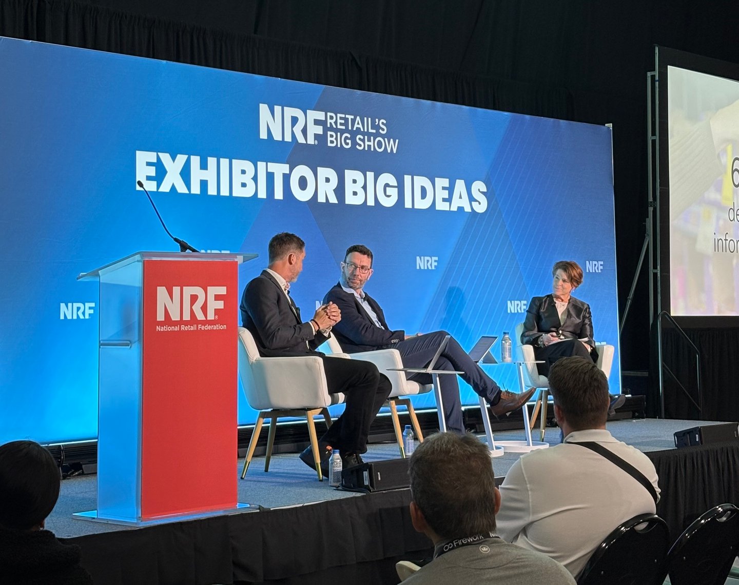 People sitting on a stage at NRF
