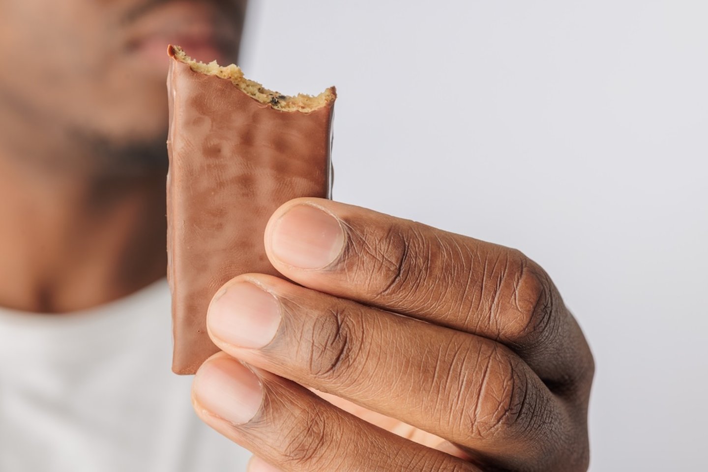 Man holding a bitten chocolate bar