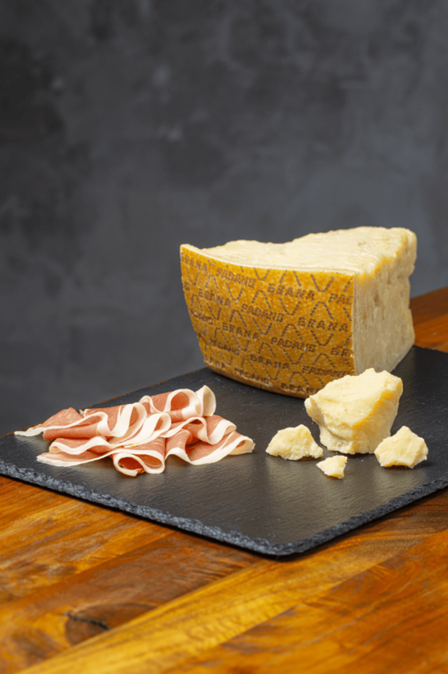 Cheese on a board with slices of meat