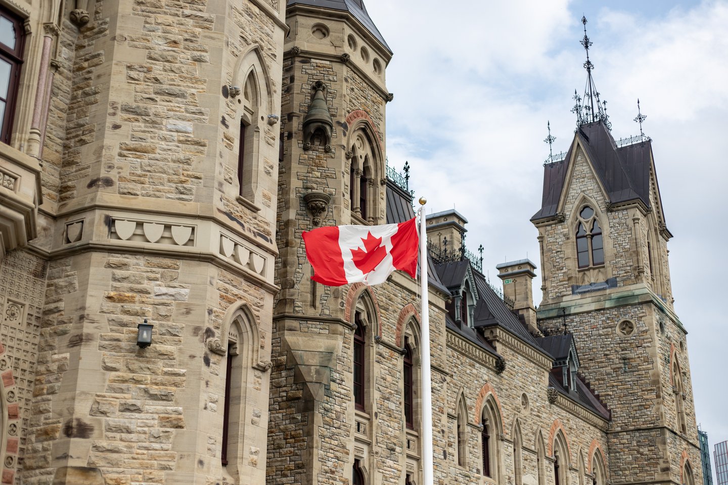 Canadian flag waving near the Parliament Hill building in Ottawa