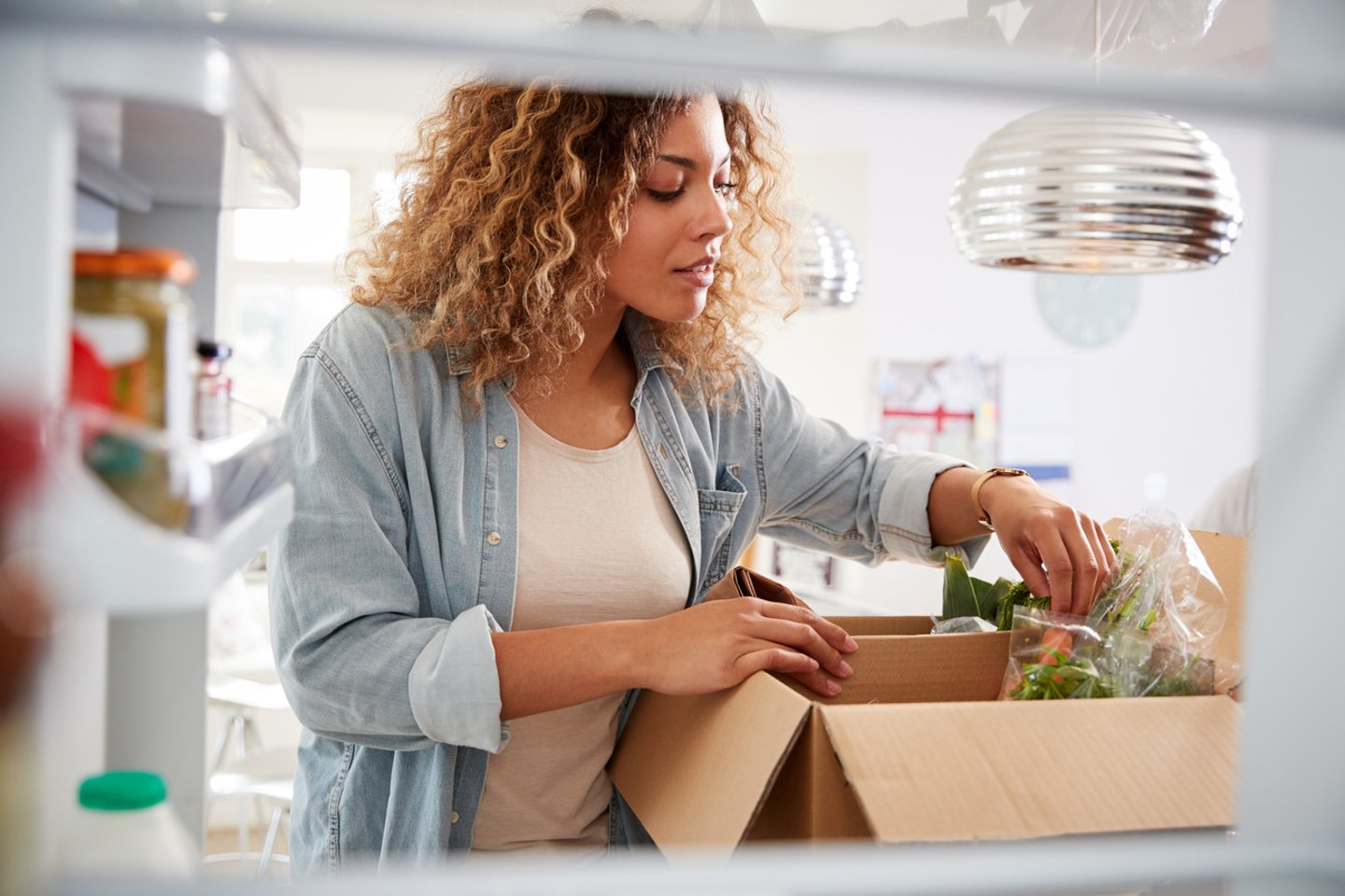 View Looking Out From Inside Of Refrigerator As Woman Unpacks Online Home Food Delivery; Shutterstock ID 1459827464