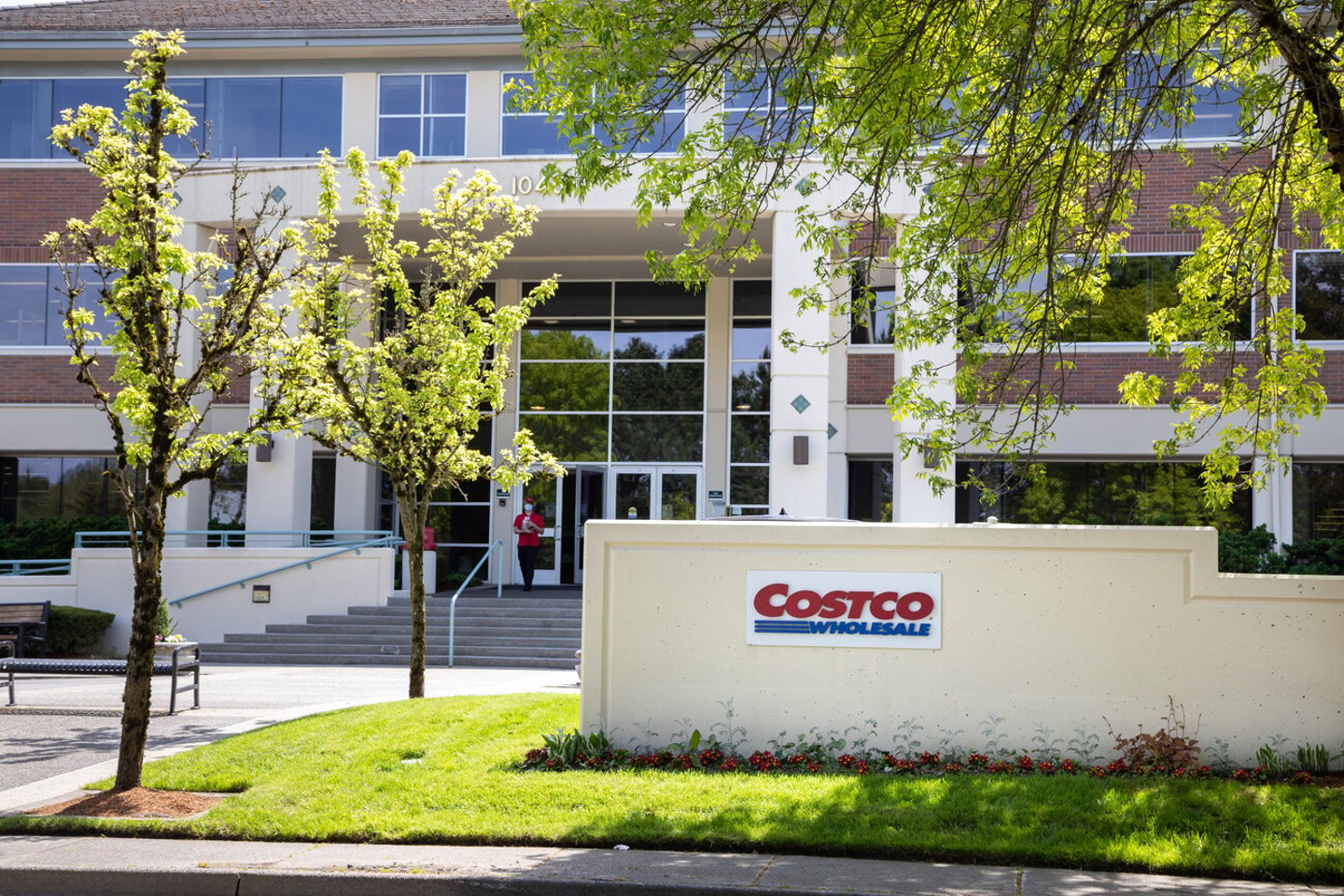 Issaquah, Washington / USA - May 4 2020:  Costco headquarters building with mask covered employee leaving the corporate offices; Shutterstock ID 1724234740