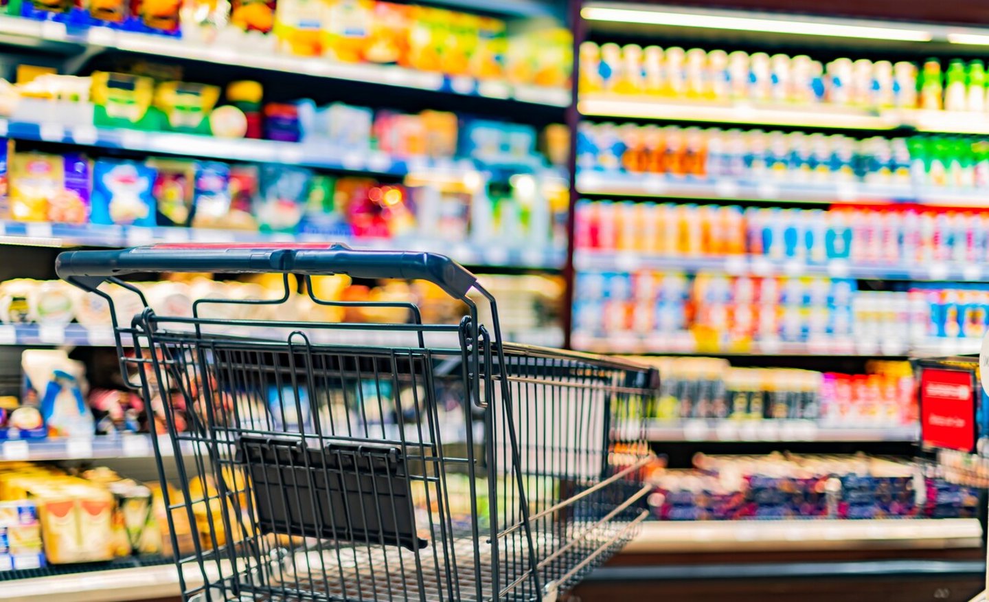 A shopping cart by a store shelf in a supermarket; Shutterstock ID 2265229445