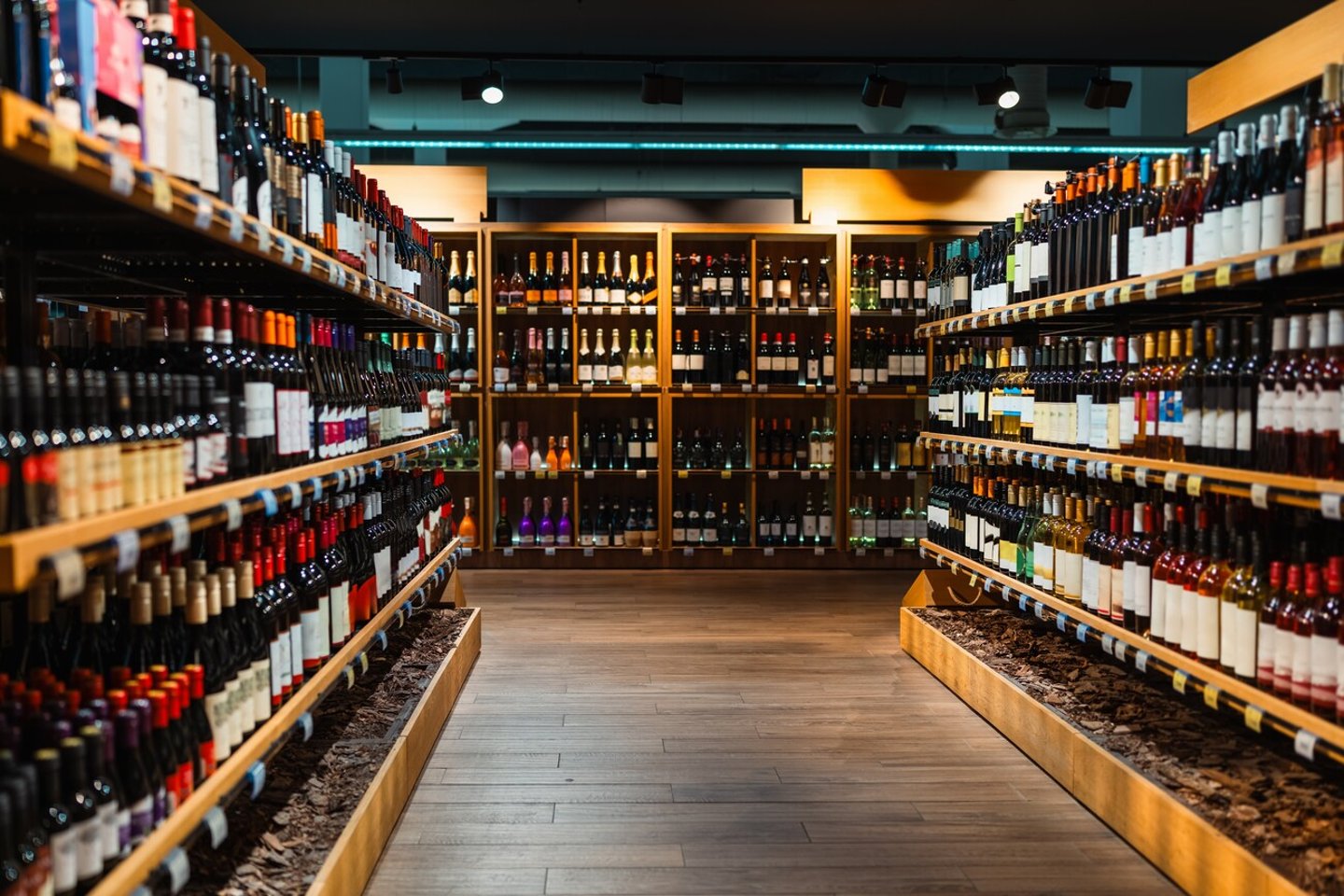 Liquor store background. Alcohol retail industry. Wine bottles on shelves in wine shop.; Shutterstock ID 2391666941