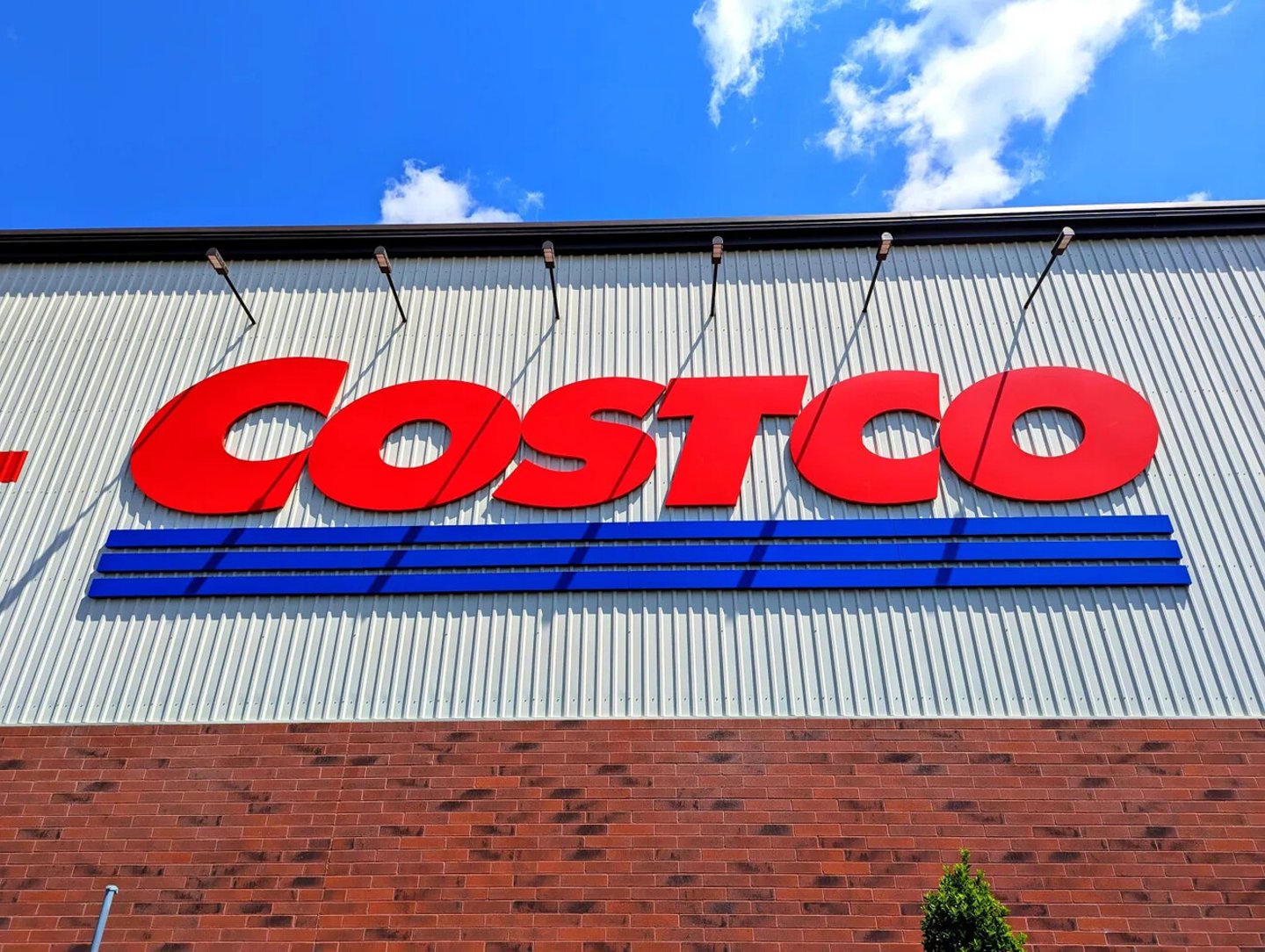 Raleigh, North Carolina - May 2 2025: Costco Wholesale Gold Star Membership Card Held In Hand in Front of Storefront Location; Shutterstock ID 2622014439