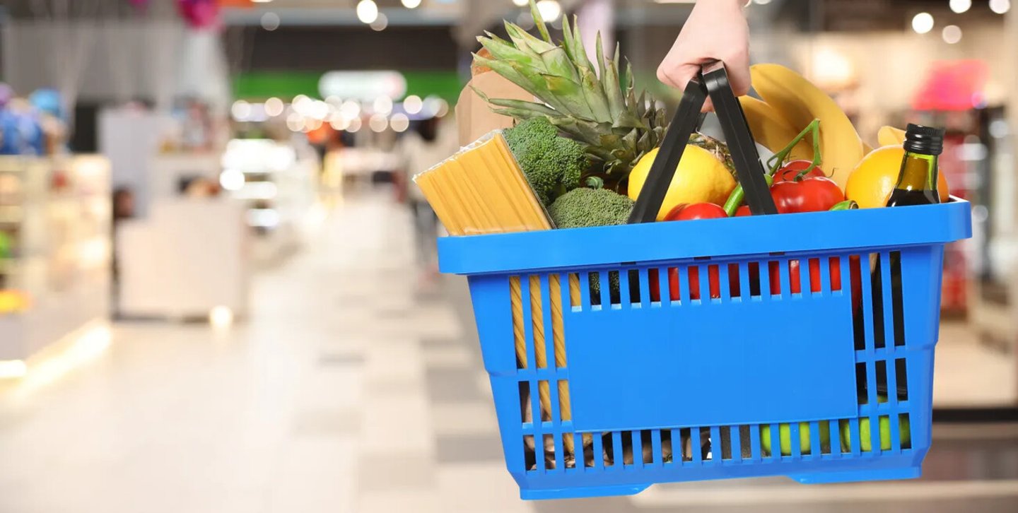 Customer holding shopping basket with different food products at supermarket, closeup. Banner design; Shutterstock ID 2704474369