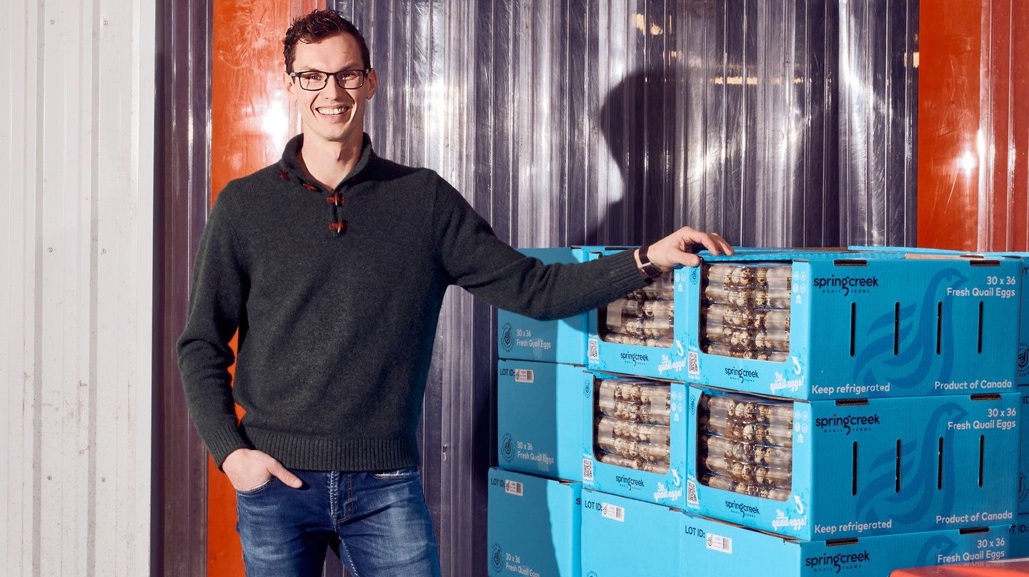 Aaron Oosterhoff stands in front of crates of quail eggs