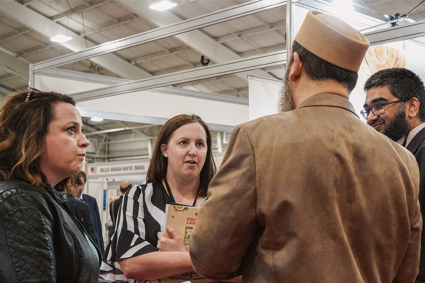 A group of men and women standing around talking