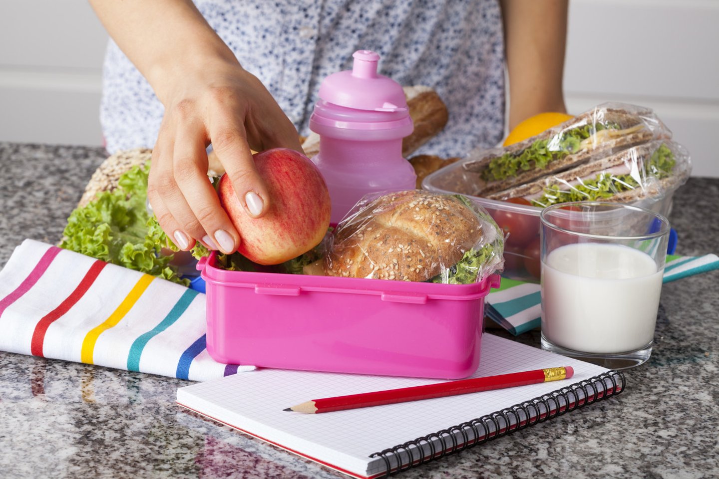 Woman preparing lunchboxes with fruits and sandwiches for school; Shutterstock ID 167098463