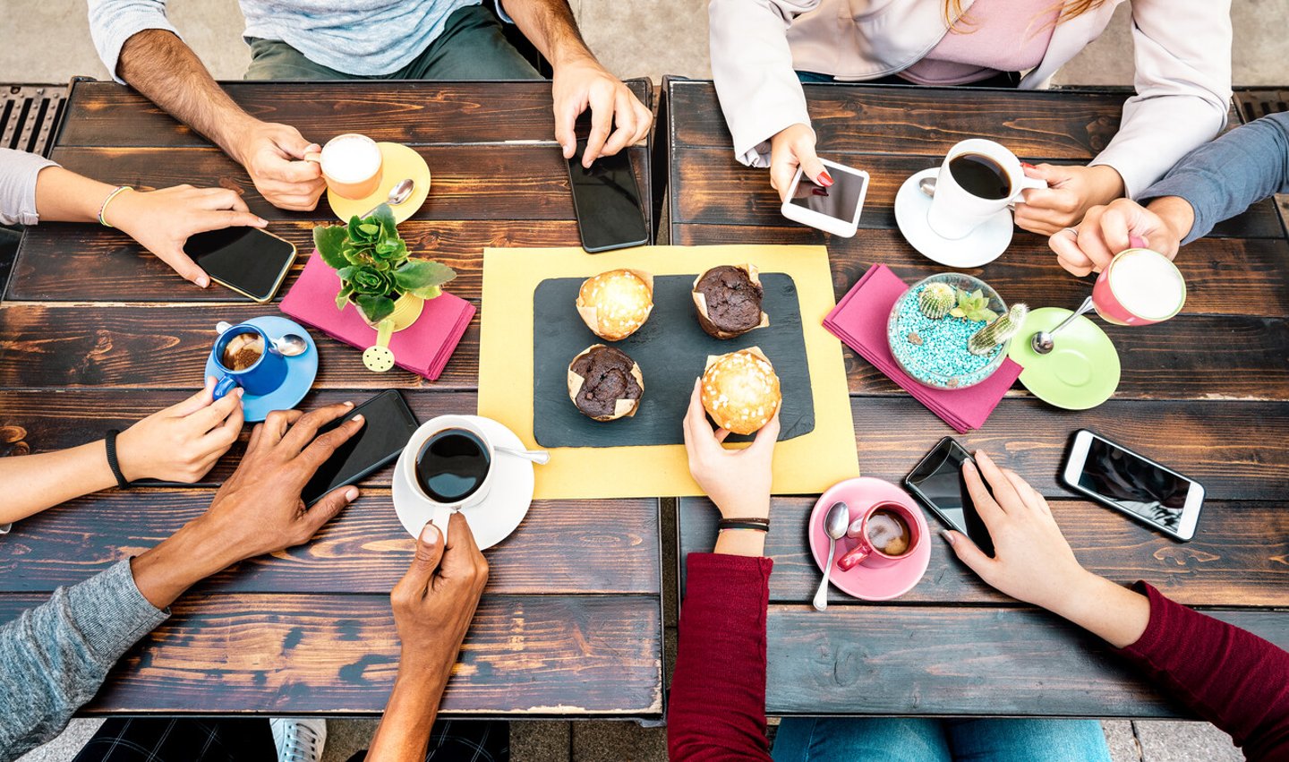 Top angle view of hands with phones at coffee shop restaurant - People having breakfast together with mobile smartphones at fashion cafe bar - Lifestyle concept on vivid filter; Shutterstock ID 1815257243