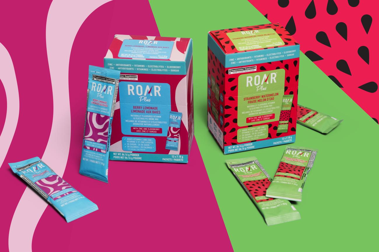 Two boxes of ROAR Plus and four single-serve packs of ROAR Plus against a colourful backdrop