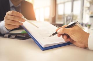 Two individuals overseeing and signing a contract
