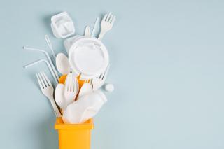 White single use plastic in garbage bin on blue background. Concept of Recycling plastic. Flat lay, top view