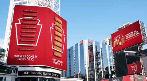 Billboards in Toronto's Yonge Dundas Square ask manufacturers to ensure the hot dog bun ratio match