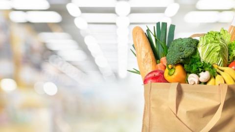 Eco friendly reusable shopping bag filled with vegetables on a blur background