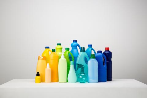 Still life of different types of plastic packaging on white and grey set arranged by colours