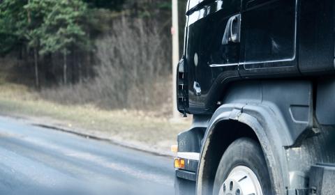 Black transport truck driving along a highway
