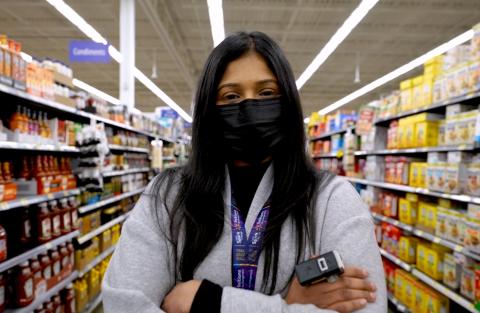 Walmart associate in the grocery aisle wearing a ring scanner