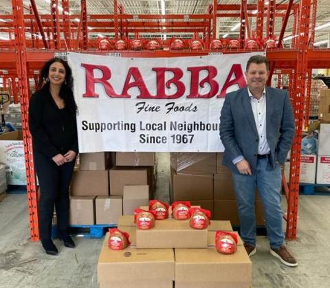 Rima Rabba, leader of the Rabba Roots Community Giving Program and Stephen Carroll, customer business development manager at Maple Leaf Foods deliver hams to The Mississauga Food Bank in time for Easter weekend. Photography courtesy Rabba Fine Foods