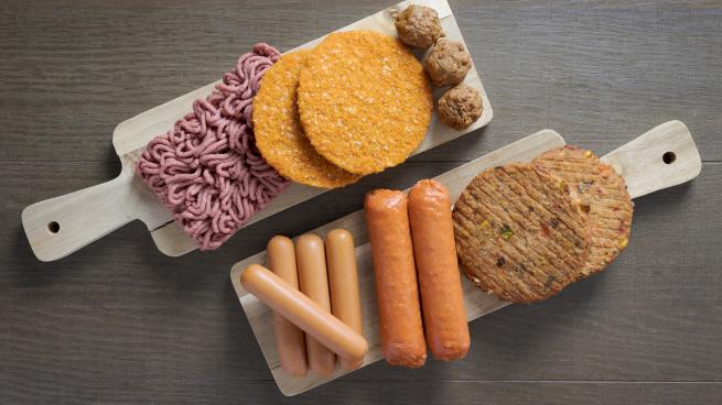Flat lay of plant based vegetarian meat products for a plant based diet on a wooden table