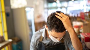 A male grocery store worker wearing a mask